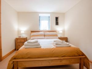 une chambre avec un lit avec des serviettes dessus dans l'établissement Hendre Cottage, à Trawsfynydd