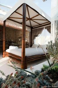 a bedroom with a canopy bed on a patio at Le Mas des Mathes, Chambres d'hôtes, Studios in Les Mathes
