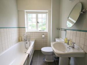 a bathroom with a tub and a sink and a toilet at Kettle Cottage in Chipping Campden +13 photos