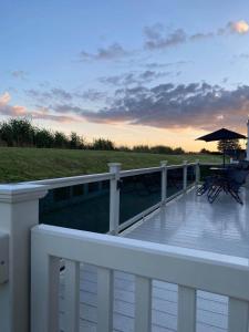 a deck with chairs and an umbrella on a house at Luxury Holiday Home in Anderby Creek in Anderby +17 photos