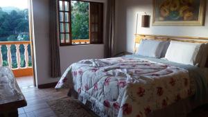 a bedroom with a bed and a window at Pousada Pinhalense in Santo Antônio do Pinhal