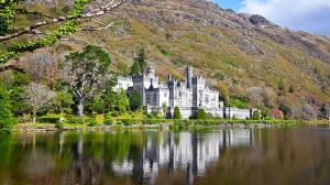 a large castle sitting on the shore of a lake at Griffin Lodge Guesthouse in Galway
