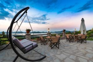 a swing on a patio with a table and chairs at Archontiko Zakoni in Neochori