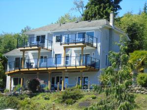 Una gran casa blanca con balcones. en The Oceanfront Inn on Stephens Bay en Coal Harbour