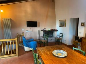 salon z drewnianym stołem i telewizorem w obiekcie Podere par di rota w mieście Calci