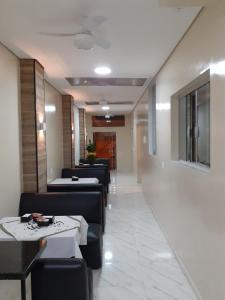 a dining room with couches and tables and a hallway at Hotel Rio Claro in Rio Claro