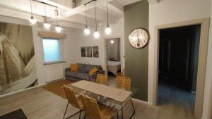 a living room with a table and a clock on a wall at Appartamenti il borgo girasole in Busca