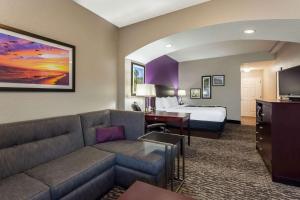 um quarto de hotel com um sofá e uma cama em La Quinta by Wyndham Port Orange / Daytona em Port Orange