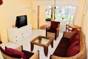 sala de estar con sofá, sillas y TV en VILLA PARA 5 Personas 4 adultos y 1 Menor En HOTEL TSORO IXTAPA WIFI GRATIS, en Ixtapa