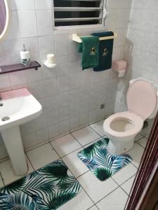La salle de bains est pourvue de toilettes, d'un lavabo et de serviettes. dans l'établissement Gite Belvédère Deshaies, à Deshaies