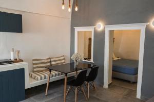 eine Küche und ein Esszimmer mit einem Tisch und einem Bett in der Unterkunft Villa LuxL in Fira