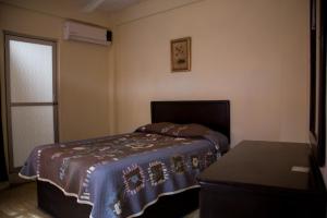 a bedroom with a bed with a blue blanket at HOTEL POSADA DEL CORTEZ in La Paz