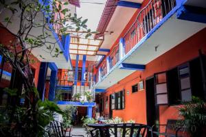 a hallway with colorful buildings with tables and chairs at HOTEL POSADA DEL CORTEZ in La Paz