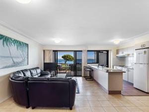 a living room with a couch and a kitchen at Florentine 2 sensational waterviews and pool in complex in Nelson Bay