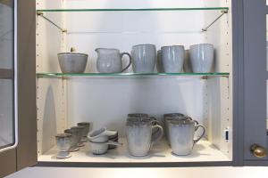 a cabinet filled with blue and white cups on shelves at ApartmentInCopenhagen Apartment 1400 in Copenhagen