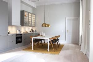ApartmentInCopenhagen Apartment 1400 في كوبنهاغن: مطبخ فيه طاولة بيضاء وكراسي
