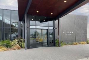 une vue extérieure d'un bâtiment avec une porte tournante dans l'établissement Sudima Hotel Christchurch Airport, à Christchurch