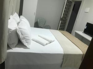 Una cama blanca con dos toallas blancas encima. en HOTEL CASABLANCA, en Aparecida de Goiania