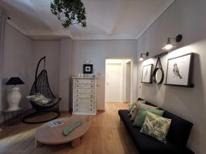 a living room with a couch and a table at Between sky and sea in an exclusive village full of charm with a private terrace in Campiglia Marittima
