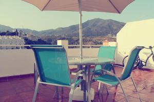 een tafel en stoelen met een parasol op een balkon bij Penthouse Near The Beach in Fuengirola