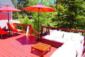 eine Holzterrasse mit einem Sofa und einem Sonnenschirm in der Unterkunft Dream Getaway-Secluded Hot Spa-Walk to Village-Walk to Pineknot Trailhead-Plus King Bed! in Big Bear Lake + 45 Fotos