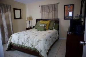 a bedroom with a bed with a white comforter at Great Location near Downtown & Airport in Tampa