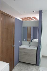 a bathroom with a sink and a mirror at Apartamentos Coronado in Málaga