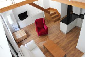 una vista aérea de una sala de estar con una silla roja en Apartamentos Coronado, en Málaga