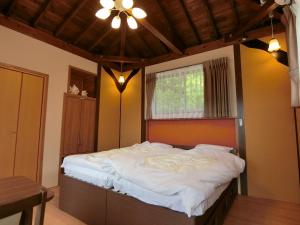 Säng eller sängar i ett rum på Shirahama Meiji Villa