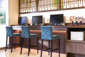 a bar with two chairs and two monitors at The Bridge Hotel Shinsaibashi in Osaka