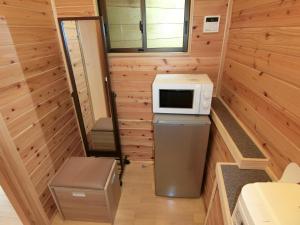 a tiny house with a microwave on top of a refrigerator at Shirahama Meiji Villa in Shirahama