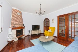 Una sala de estar con un sofá y una chimenea. en Sunrise Terrace Peniche, en Peniche