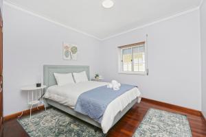 Un dormitorio con una cama con un osito de peluche encima. en Sunrise Terrace Peniche, en Peniche