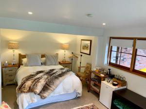 a bedroom with a bed with a blanket on it at Mill Cottage - boutique accommodation and garden in Akaroa