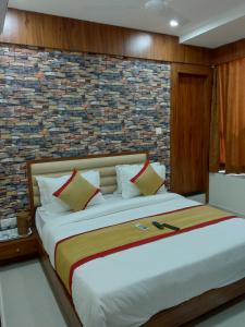 1 dormitorio con 1 cama grande y pared de ladrillo en hotel restandride, en Anand