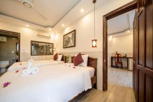 Postel nebo postele na pokoji v ubytování Bonsai Villa Hoi An