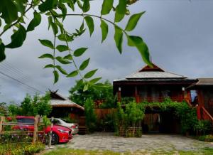 ラムパーンにあるLampang Lanna Homeの赤い車が目の前に停まっている家