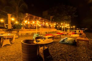 a patio with tables and lights at night at Amed Beach Resort in Amed