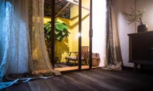 Habitación con espejo, cortinas y silla en Leranda Homestay, en Hue