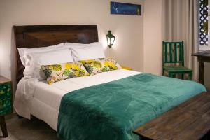 a bedroom with a bed and a table and a chair at Pousada Rua de Lazer in Domingos Martins