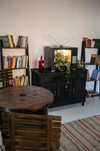 a dining room with a table and a tv on a cabinet at Pousada Rua de Lazer in Domingos Martins