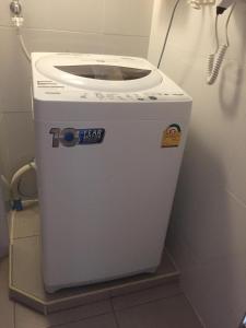 a washing machine is sitting in a bathroom at PMY Beach Resort in Rayong