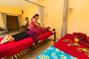 a woman sitting on a bed in a room at Amed Beach Resort in Amed