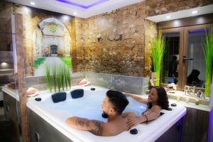 un homme et une femme dans une baignoire dans l'établissement LA VEGUILLA DELUXE JACUZZi, à Alhama de Aragón