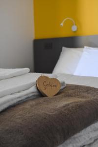 a wooden sign sitting on top of a bed at Agriturismo La Casa Gialla in Romagnano