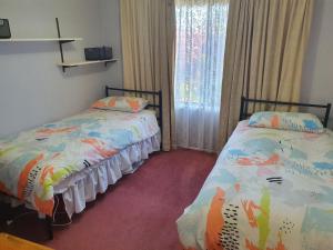 a bedroom with two beds and a window at The Greenery in Castlemaine