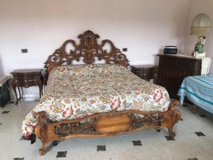 um quarto com uma cama de madeira com uma colcha em Villa di Nonno Remo em Rapino