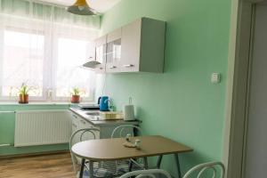a kitchen with a table and a table and chairs at Aloé Apartman Sopron in Sopron