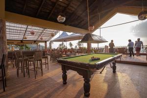 a pool table in the middle of a patio with people at Alcove Resort Vagator in Vagator