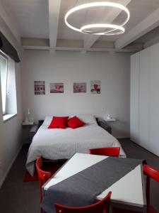 Schlafzimmer mit einem Bett und einem Tisch mit roten Stühlen in der Unterkunft Appartamenti il borgo papavero in Busca